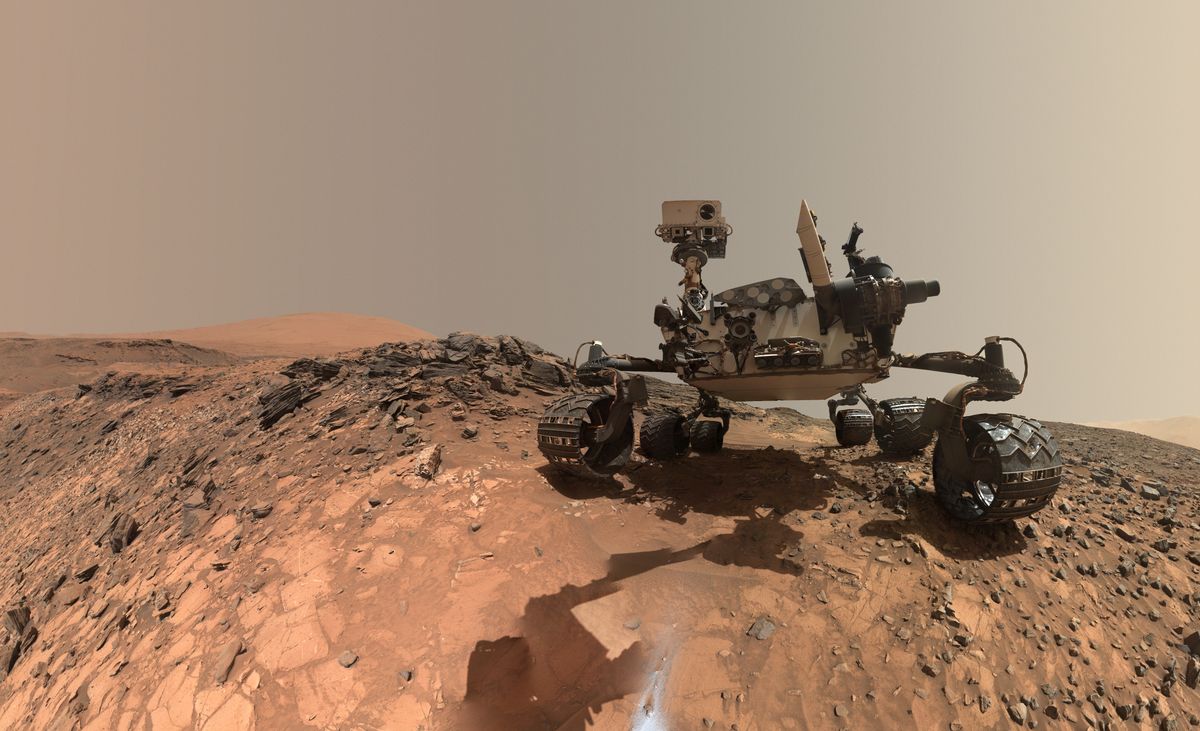 This low-angle self-portrait of NASA’s Curiosity Mars rover shows the vehicle at the site from which it reached down to drill into a rock target called “Buckskin” on lower Mount Sharp. The selfie combines several component images taken by Curiosity’s Mars Hand Lens Imager (MAHLI) on Aug. 5, 2015, during the 1,065th Martian day, or sol, of the rover’s work on Mars. For scale, the rover’s wheels are 20 inches (50 centimeters) in diameter and about 16 inches (40 centimeters) wide. This view is a portion of a larger panorama.